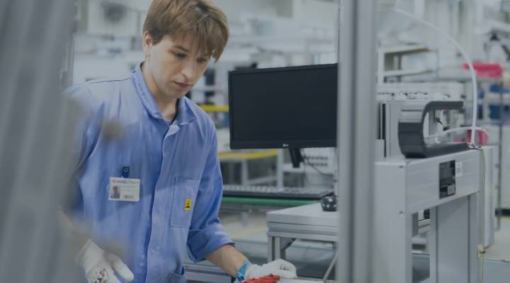 inżynier przy automatycznym dyspenserze, w rękawiczkach i z opaską ESD